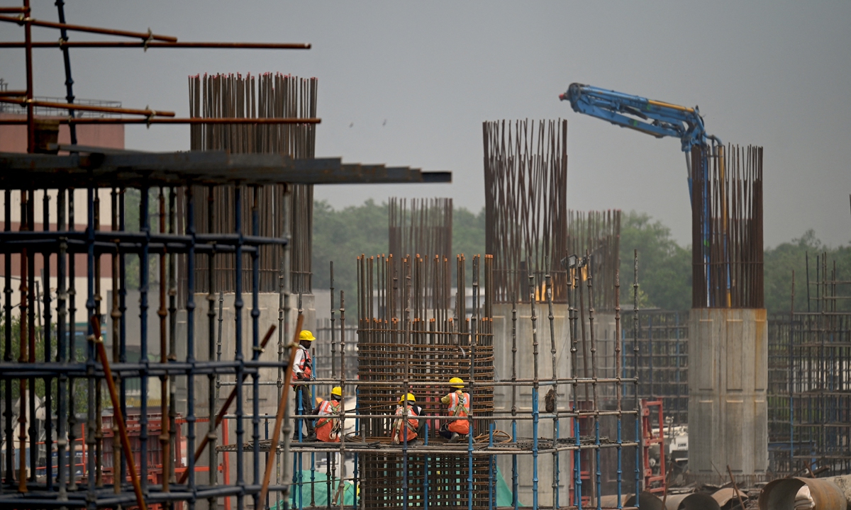 Workers assemble metal rods to make a concrete pillar at a flyover construction site in New Delhi, India on May 26, 2022. India’s economy is expected to have grown at 9.2 percent in the fiscal year that ended in March 2022, said the Business Standard. Photo: AFP