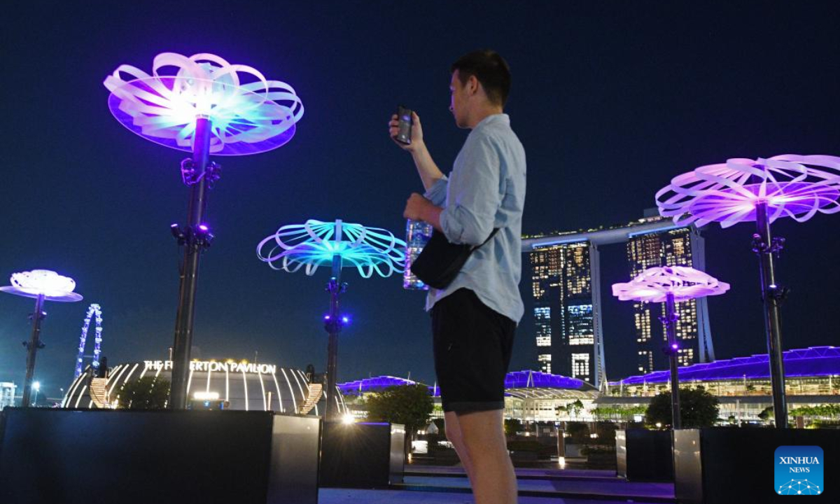 A visitor takes photos of the installations of the light show i Light Singapore at the Marina Bay area in Singapore, June 1, 2022. Photo:Xinhua