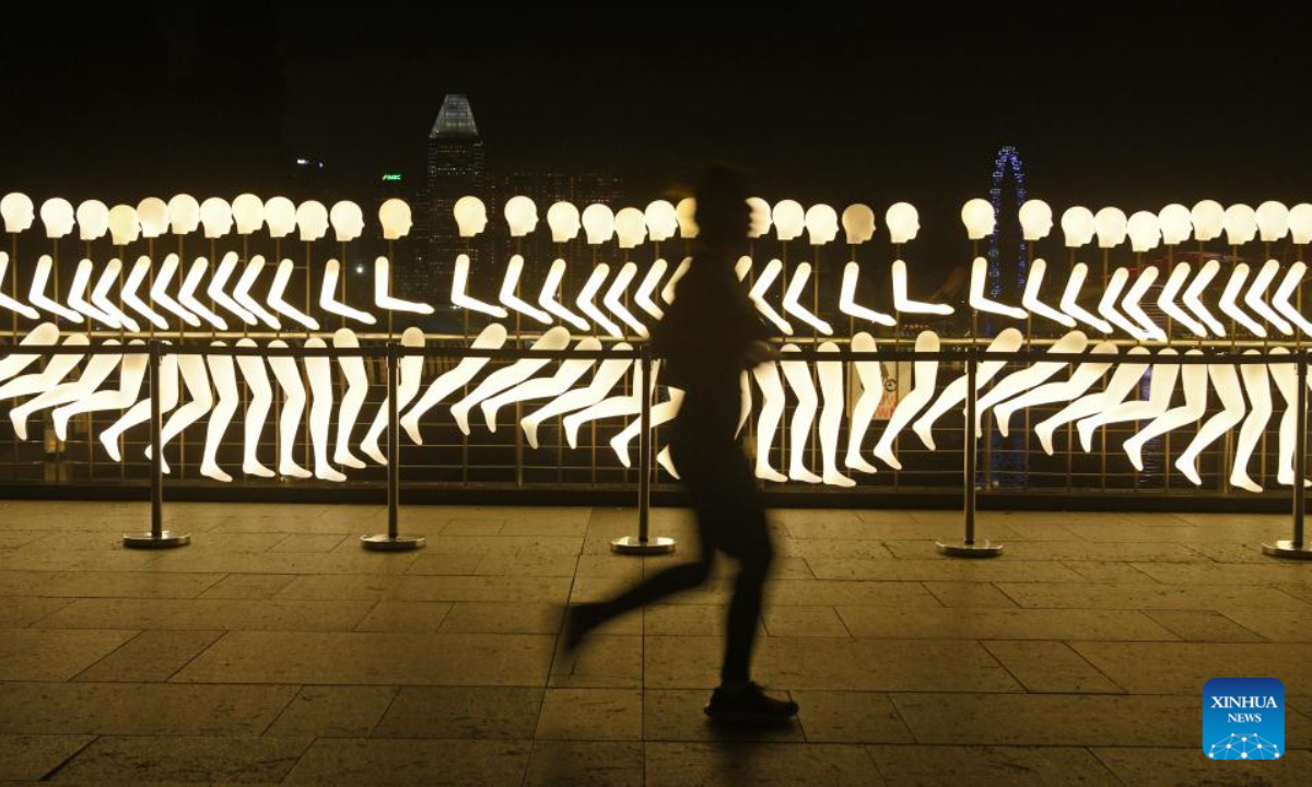 A jogger runs past the installations of the light show i Light Singapore at the Marina Bay area in Singapore, June 1, 2022. Photo:Xinhua