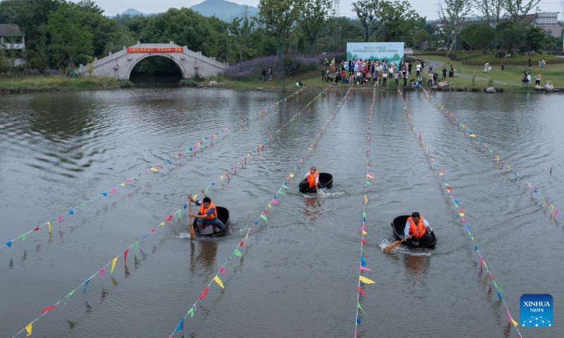 Aerial photo shows villagers taking part in a barrel rowing competition in Baoguo Village, Donglin Township of Huzhou, east China's Zhejiang Province, May 28, 2022. More than 30 contestants from nearby villages attended the competition ahead of the upcoming Dragon Boat Festival. This kind of barrel is a traditional tool used by the locals to conduct agricultural activities on water including fishing, water chestnuts and lotus seedpods picking. (Xinhua/Xu Yu)