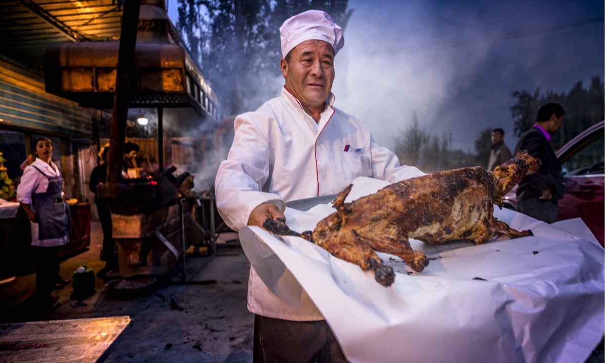 A cook serves up a roasted whole lamb in Hotan Prefecture in Northwest China's Xinjiang Uygur Autonomous Region in 2017.Photo: VCG