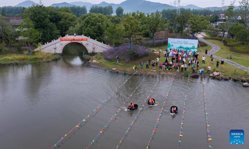 Aerial photo shows villagers taking part in a barrel rowing competition in Baoguo Village, Donglin Township of Huzhou, east China's Zhejiang Province, May 28, 2022. More than 30 contestants from nearby villages attended the competition ahead of the upcoming Dragon Boat Festival. This kind of barrel is a traditional tool used by the locals to conduct agricultural activities on water including fishing, water chestnuts and lotus seedpods picking. (Xinhua/Xu Yu)