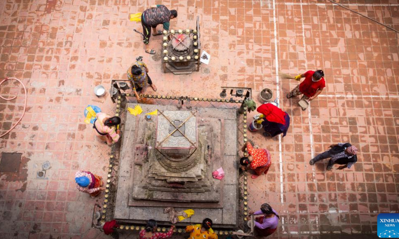 People clean the courtyard and stupa on the occasion of Sithi Nakha Festival in Lalitpur, Nepal, June 5, 2022. The Newar community celebrates the Sithi Nakha festival to mark the beginning of monsoon season by cleaning water sources such as ponds, wells and stone spouts. People also prepare traditional pancakes such as Bara and Chatamari as a tribute to their ancestral god. Photo: Xinhua