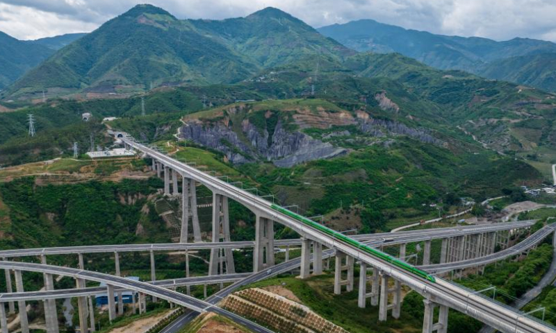 Aerial photo shows a Fuxing bullet train running through Nanxihe grand bridge on the China-Laos Railway in southwest China's Yunnan Province, June 2, 2022. The China-Laos Railway, half a year into its operation, has delivered more than 4 million tonnes of freight as of Thursday, China's railway operator said. The transport volume of cross-border cargo came in at 647,000 tonnes during the period, according to the China State Railway Group Co., Ltd. The train line also handled over 3.2 million passenger trips, said the operator. Since December 2021, 21 Chinese regions have designated cross-border trains for freight transport along the railway, with goods including fertilizers, daily necessities, electronics and fruits. As a landmark project under the Belt and Road Initiative, the 1,035-km China-Laos Railway connects China's Kunming with the Laotian capital Vientiane. (Xinhua/Jiang Wenyao)