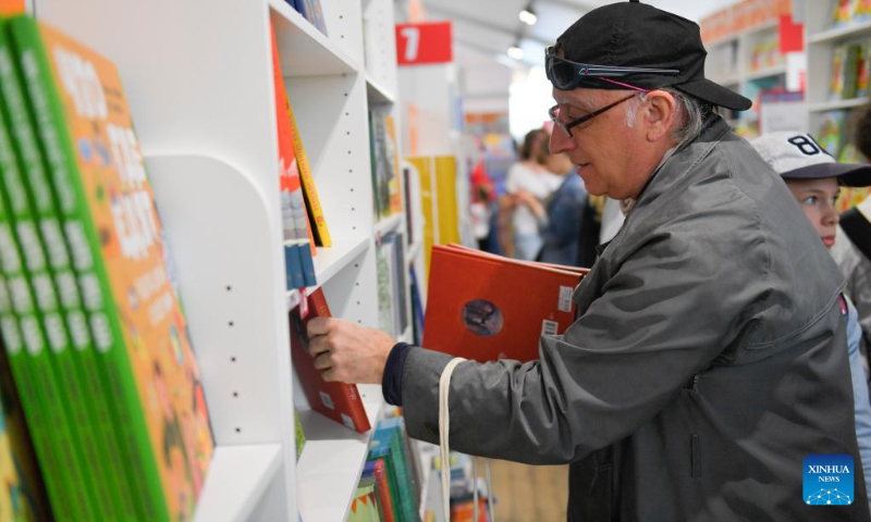 A man selects books at the annual book festival on the Red Square in Moscow, Russia, on June 3, 2022. (Photo by Alexander Zemlianichenko Jr/Xinhua)