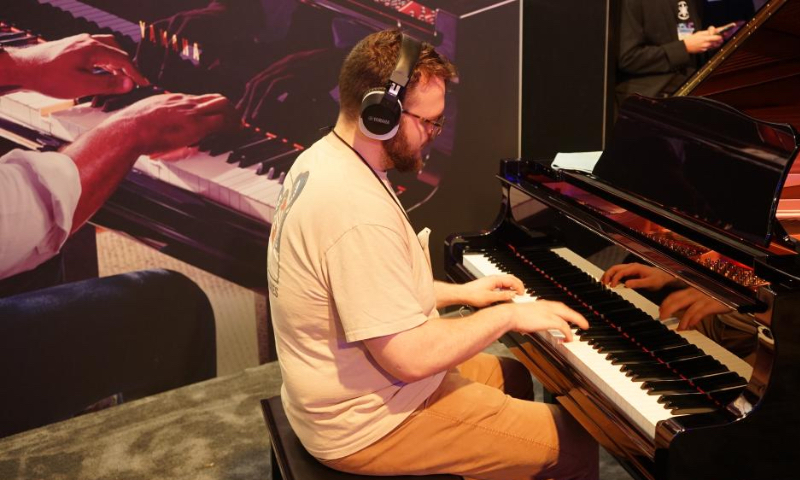 A man plays the piano during the 2022 National Association of Music Merchants (NAMM) Show in Anaheim, the United States, June 3, 2022. (Photo by Zeng Hui/Xinhua)