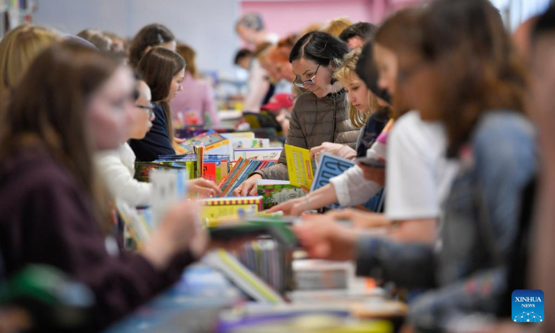 People select books at the annual book festival on the Red Square in Moscow, Russia, on June 3, 2022. (Photo by Alexander Zemlianichenko Jr/Xinhua)
