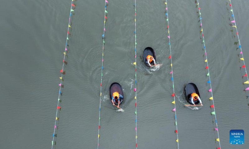Aerial photo shows villagers taking part in a barrel rowing competition in Baoguo Village, Donglin Township of Huzhou, east China's Zhejiang Province, May 28, 2022. More than 30 contestants from nearby villages attended the competition ahead of the upcoming Dragon Boat Festival. This kind of barrel is a traditional tool used by the locals to conduct agricultural activities on water including fishing, water chestnuts and lotus seedpods picking. (Xinhua/Xu Yu)