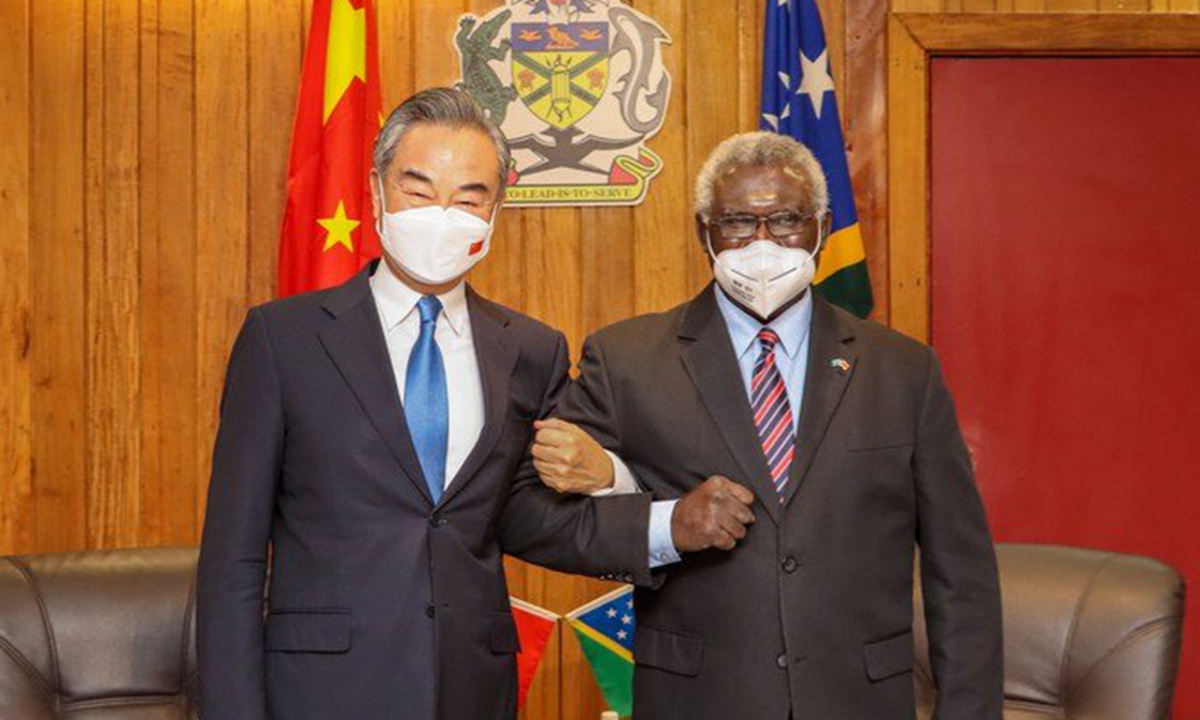 Chinese State Councilor and Foreign Minister Wang Yi (left) holds arms with Solomon Islands Prime Minister Manasseh Sogavare after arriving in Solomon Islands for a visit on May 26, 2022. Photo: Courtesy of Chinese Ministry of Foreign Affairs