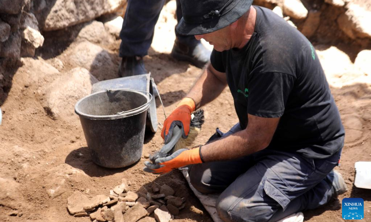 A staff member of the Israel Antiquities Authority (IAA) works at an excavation site next to Arbel stream near Tiberias, Israel, on May 26, 2022. Israeli archaeologists have discovered a well-preserved ancient agricultural farmstead, dated back to 2,100 years ago, the Israel Antiquities Authority (IAA) said on Wednesday. Photo:Xinhua
