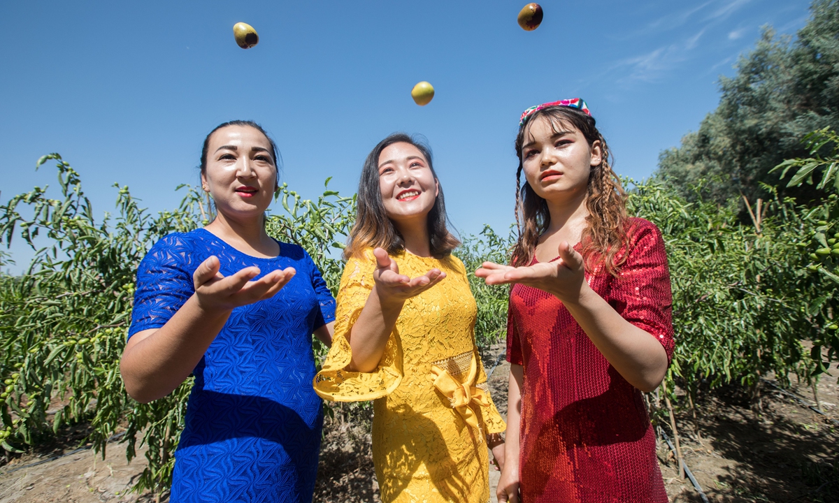 Three women take photos at a winter jujube field in Alar, Xinjiang. Photo: VCG 