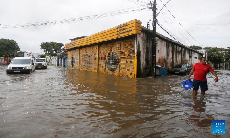 A man walks on a flooded street after heavy rains in Recife, Brazil, June 3, 2022. The death toll from heavy rains in Recife, capital of the Brazilian state of Pernambuco, and its metropolitan area has risen to 128, local authorities said Friday. (Photo by Lucio Tavora/Xinhua)