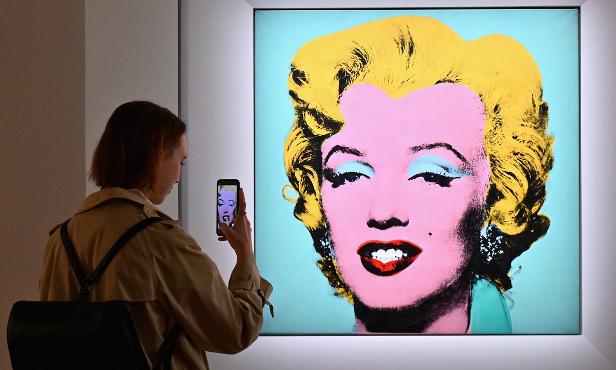 A woman takes a photo of Andy Warhol's Shot Sage Blue Marilyn on April 29, 2022 in New York City. Photo: AFP