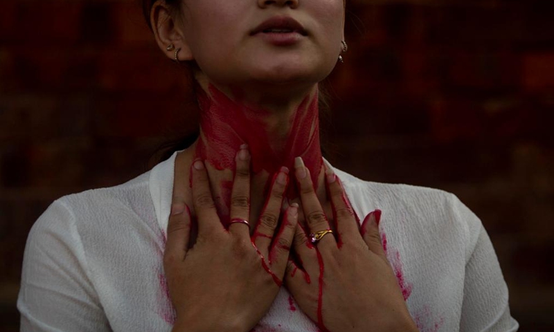 A girl takes part in a paint-me-red campaign against sexual violence in Lalitpur, Nepal, May 28, 2022.Photo:Xinhua