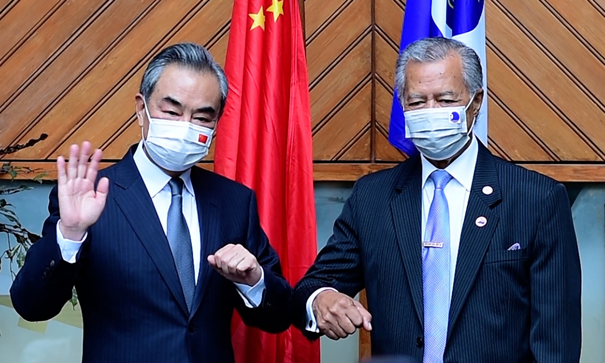 Chinese State Councilor and Foreign Minister Wang Yi (left) and Secretary-General of the Pacific Islands Forum Henry Puna pose for a picture during their meeting in Suva, capital of Fiji, on May 29, 2022.