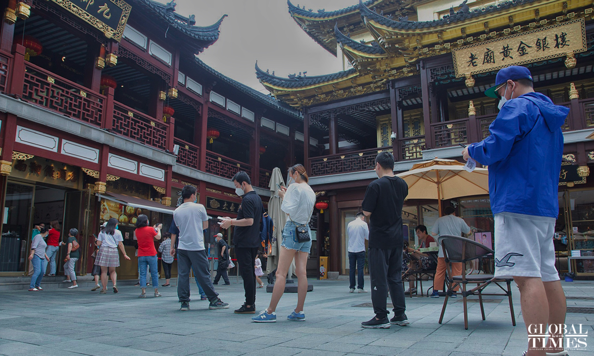 On the first day of Shanghai resuming normal life, one of the main attractions in the city, the Yuyuan Garden welcomes tourists on June 1. Visitors take photos and many time-honored brand restaurants welcome customers. At present, the scenic spot requires visitors to make an appointment and show their health code to enter. Photo: Wu Shiliu/GT