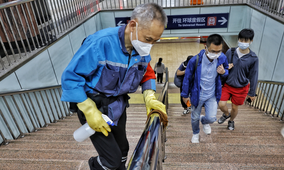 A worker disinfects handrails during morning rush hour at the Guomao subway station in Beijing on May 30. Photo: Li Hao/GT