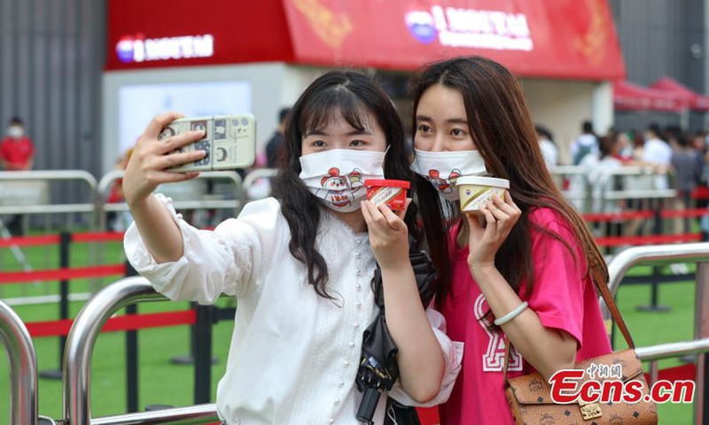 Customers take photos with the ice cream at the flagship store of Moutai ice cream in Guigyang, southwest China's Guizhou Province, May 29, 2022.Photo:China News Service