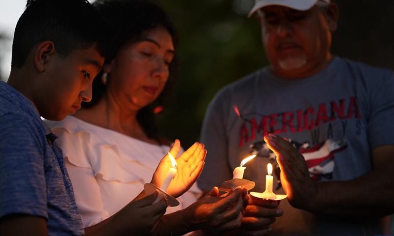 People attend a vigil to mourn for victims of a school mass shooting at Town Square in Uvalde, Texas, the United States, May 29, 2022. At least 19 children and two adults were killed in a shooting at Robb Elementary School in the town of Uvalde, Texas, on Tuesday. (Xinhua/Wu Xiaoling)