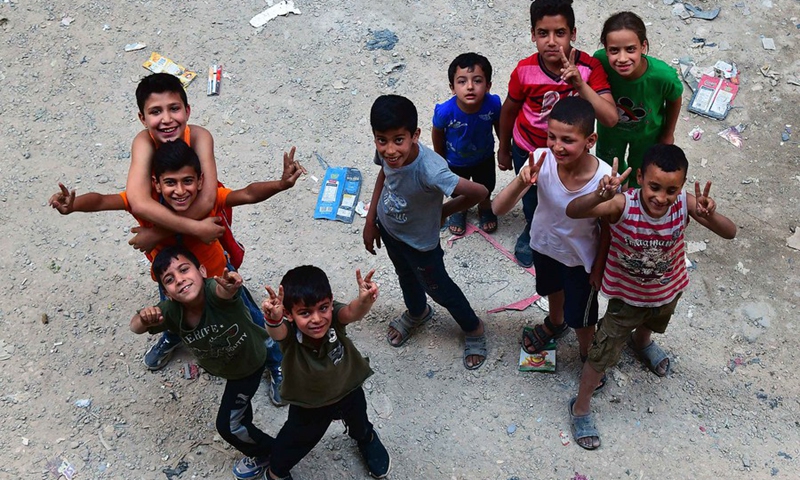Poor children wave hands in a place in the Jaraman suburb of the capital Damascus on May 25, 2022.(Photo: Xinhua)