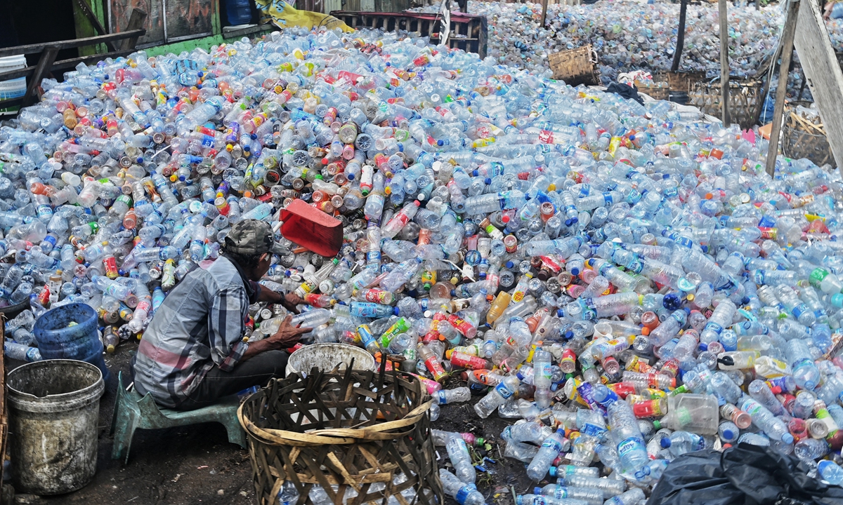 A worker collects plastic bottles to sell at a dump site in Banda Aceh on May 31, 2022. Indonesia generates approximately 7.8 million tons of plastic waste annually, with 4.9 million tons being mismanaged. Photo: AFP