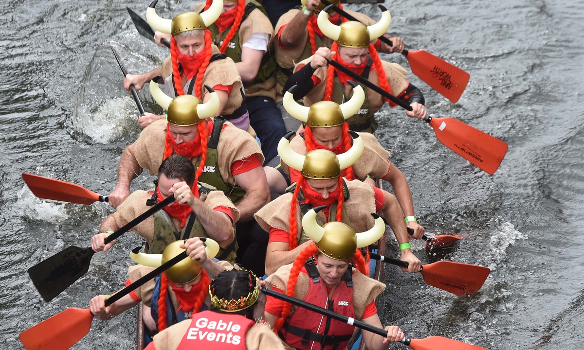 A woman helps a girl rinse her hair with iris water at a Dano event in the Korean Folk Village in Yongin city, South Korea. Photos: IC Top: Teams take part in the Chinese Dragon Boat Festival on June 18, 2016.
Left: A woman plays on a swing during the Korean Dano festival. 