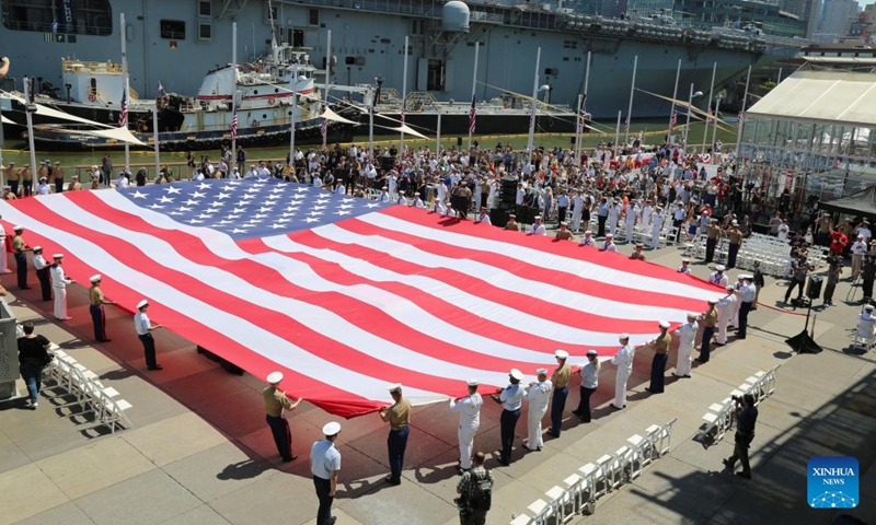 People unfurl an American flag during an event marking Memorial Day at the Intrepid Sea, Air and Space Museum in New York, the United States, on May 30, 2022. New Yorkers celebrated Memorial Day on Monday with parades and other activities, which resembled the celebrations in the time before the COVID pandemic.(Photo: Xinhua)