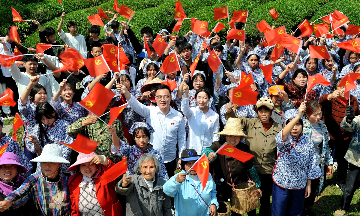 People wave CPC flags in Dexing, South China's Guangxi Zhuang Autonomous Region. Photo: VCG