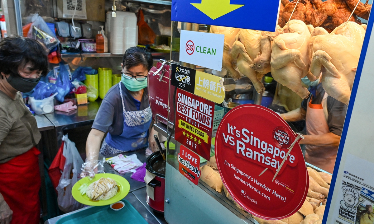 A vendor prepares a plate of chicken rice at a hawker center in Singapore on May 31, 2022. Singapore imports a third of its chicken supply from Malaysia, which will halt the export of 3.6 million chickens a month from June 1 onward, amid surging prices and supply concerns. Photo: AFP