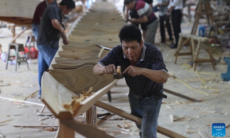Craftsmen build dragon boats at Fangzhongxiong dragon boat factory in Fangzhuang Village of Nantong Township in Minhou County of Fuzhou, southeast China's Fujian Province, May 30, 2022. Fangzhuang, known as Dragon Boat Village, has a traditional dragon boat manufacturing history for more than 700 years. Every year, more than 200 hand-made wooden boats, carefully built by craftsmen, are sold nationwide and even overseas from the village.(Photo: Xinhua)