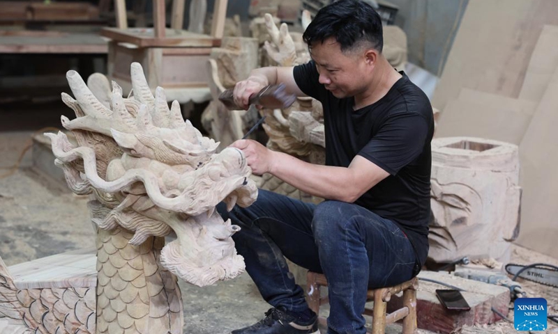 Craftsman Fang Xiaoshui carves the dragon head for a dragon boat in Fangzhuang Village of Nantong Township in Minhou County of Fuzhou, southeast China's Fujian Province, May 30, 2022. Fangzhuang, known as Dragon Boat Village, has a traditional dragon boat manufacturing history for more than 700 years. Every year, more than 200 hand-made wooden boats, carefully built by craftsmen, are sold nationwide and even overseas from the village.(Photo: Xinhua)