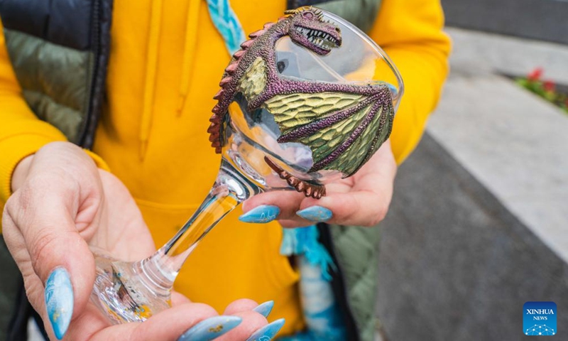 A craftswoman shows her decorated glass on a street in Vladivostok, Russia, June 4, 2022.Photo:Xinhua