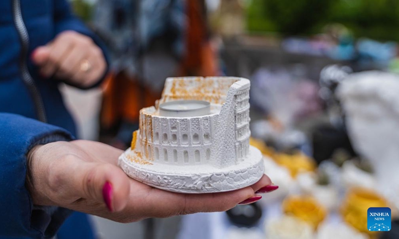 A craftswoman presents a candle holder on a street in Vladivostok, Russia, June 4, 2022.Photo:Xinhua