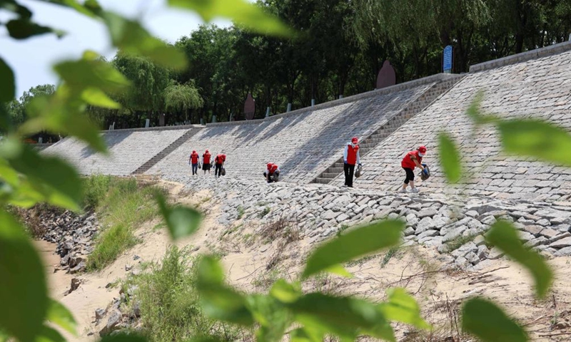 Volunteers collect wastes at the bank of Yellow River in Boxing County of Binzhou, east China's Shandong Province, June 4, 2022.Photo:Xinhua