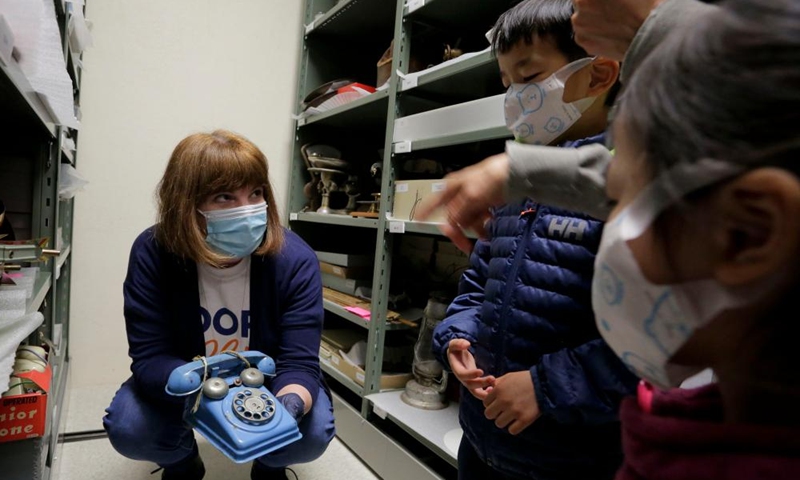 A staff member shows a metal toy telephone made in 1950s at Richmond Museum's artifact storage warehouse during the Doors Open Richmond event in Richmond, British Columbia, Canada, on June 4, 2022.Photo:Xinhua
