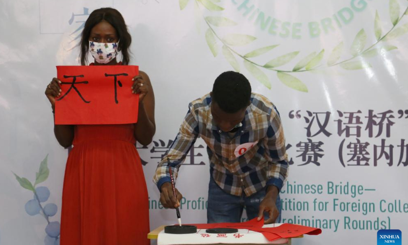 Contestants participate in the 21st Chinese Bridge Chinese proficiency competition for Senegalese college students at the Confucius Institute at Cheikh Anta Diop University of Dakar (UCAD) in Dakar, Senegal, June 8, 2022. Ten students participated in the contest organized by the Chinese Embassy in Senegal and the Confucius Institute at UCAD. Under the theme of One World One Family, the final consisted of three parts: keynote speech, knowledge quiz and talent show.  Photo: Xinhua