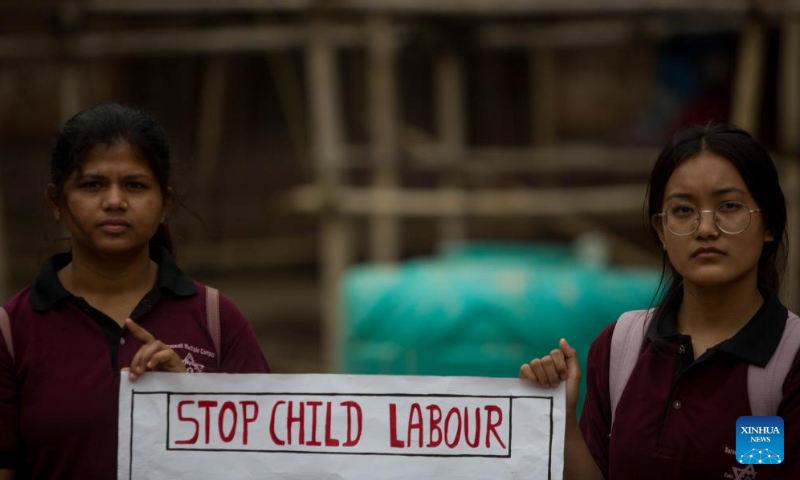 Students hold a poster to mark the World Day Against Child Labor in Kathmandu, Nepal, June 12, 2022. (Photo by Sulav Shrestha/Xinhua)
