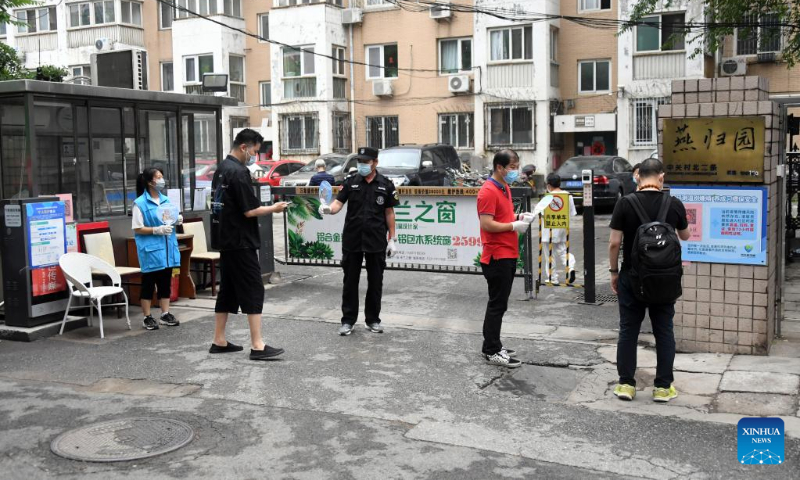 Residents scan QR codes to have their health status registered at the entrance of a residential area in Zhongguancun of Haidian District, Beijing, capital of China, June 12, 2022. Beijing's Zhongguancun area has imposed stricter COVID-19 prevention and control measures amid a recent outbreak. At the community level, these include stricter visitor information registration, health code tracking, temperature check and verification of negative COVID-19 test results. (Xinhua/Ren Chao)