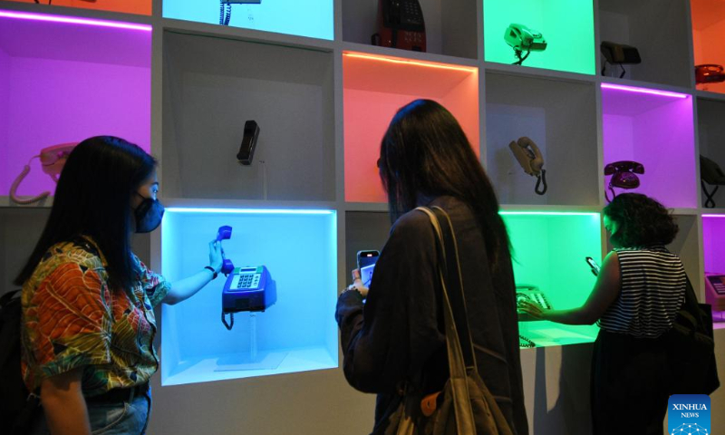Visitors view old telephones at the preview of Off/On: Everyday Technology that Changed Our Lives, 1970s-2000s exhibition at the National Museum of Singapore, June 7, 2022. Photo: Xinhua
