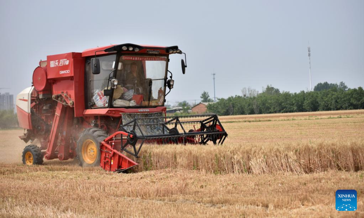 Tang Jumin drives a harvester to reap wheat in the field at Hancun Village in Xingtai, north China's Hebei Province, June 9, 2022. Photo:Xinhua