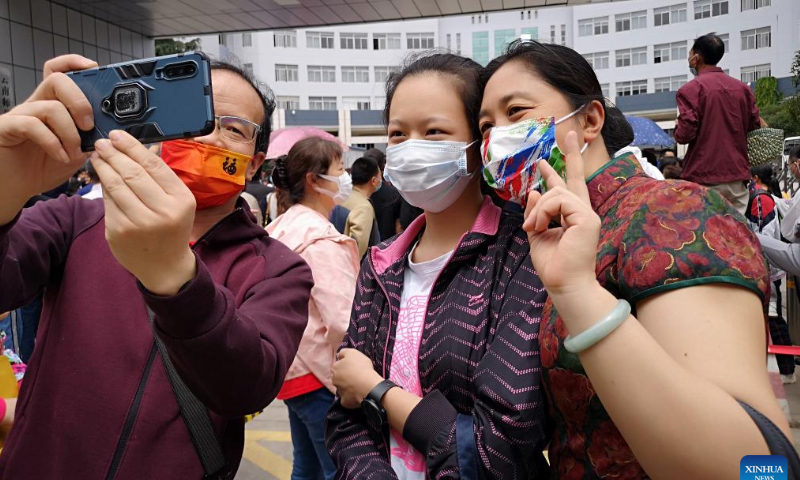A mother wearing traditional qipao dress poses for photos with her daughter at an exam site of national college entrance exam in Kunming, southwest China's Yunnan Province, June 7, 2022. Photo: Xinhua