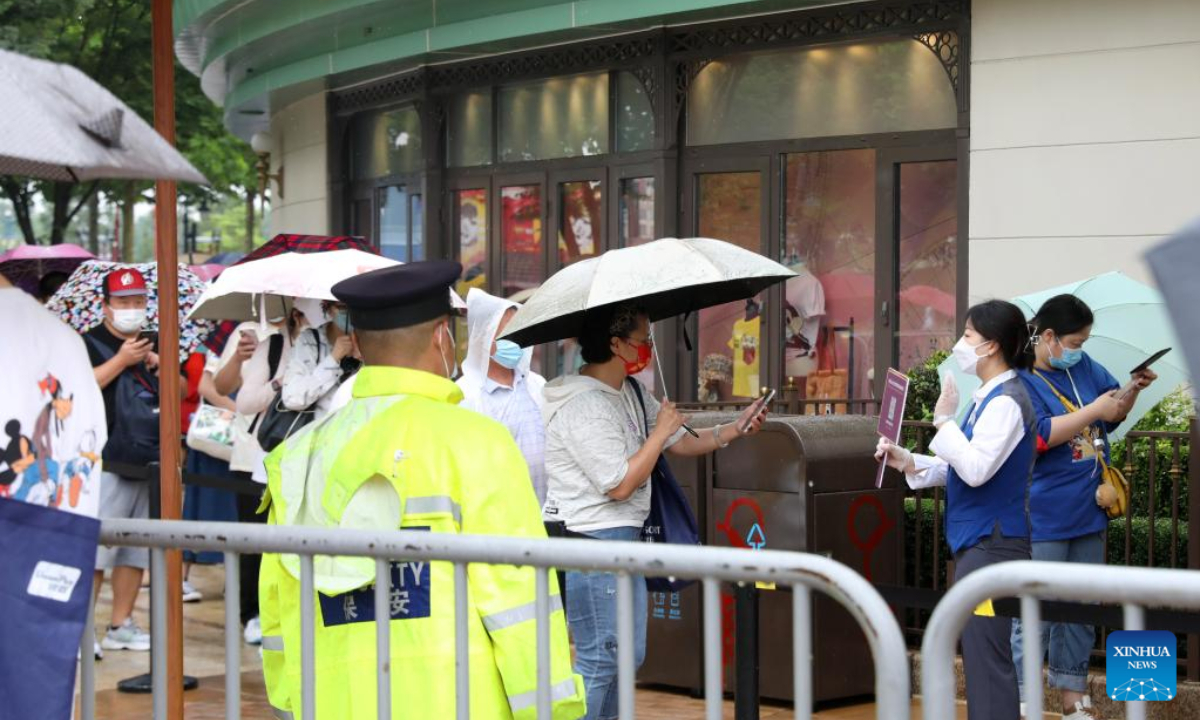 Tourists scan QR code before entering the World of Disney Store in Shanghai, east China on June 10, 2022. Shanghai Disney Resort partially resumed operations on Friday as the COVID-19 epidemic wanes in the city. Wishing Star Park, the World of Disney Store and Blue Sky Boulevard resumed operations first and Shanghai Disneyland would remain temporarily closed until further notice. Photo:Xinhua