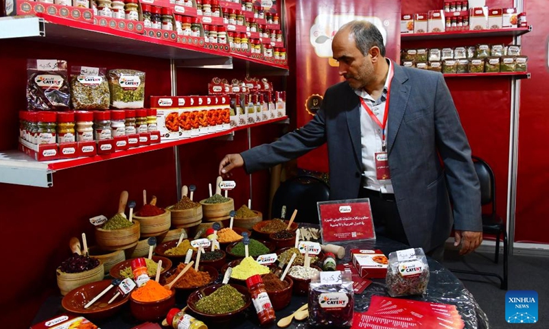 A Syrian merchant arranges his display at a food expo in Damascus, Syria, on June 5, 2022.Photo:Xinhua