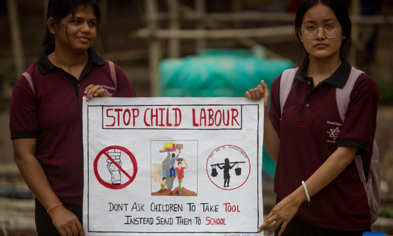 Students hold a poster to mark the World Day Against Child Labor in Kathmandu, Nepal, June 12, 2022. (Photo by Sulav Shrestha/Xinhua)