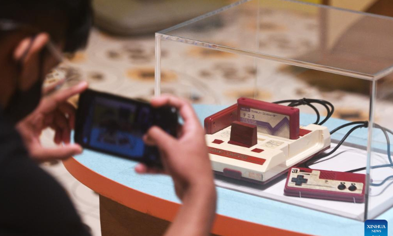 A visitor takes a photo of a Nintendo video game console at the preview of Off/On: Everyday Technology that Changed Our Lives, 1970s-2000s exhibition at the National Museum of Singapore, June 7, 2022. Photo: Xinhua