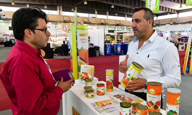 A Syrian merchant talks with a visitor at a food expo in Damascus, Syria, on June 5, 2022.Photo:Xinhua