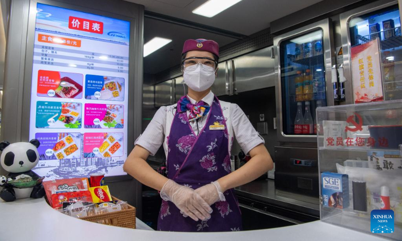 A staff member works on a train during a trial operation of the Chongqing-Wushan section of the high-speed railway linking Chongqing, southwest China, and Zhengzhou, capital of central China's Henan Province, June 14, 2022. The Zhengzhou-Chongqing High-speed Railway will be fully operational in late June, cutting the travel time between the two cities from 8 hours to 4 hours and upgrading the high-speed railway network in central China and southwest China. (Xinhua/Tang Yi)
