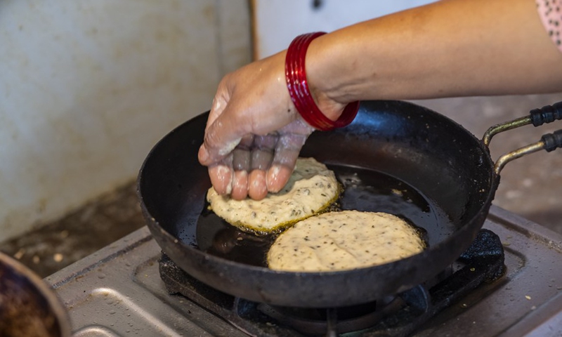 A Nepalese cooks special pancake with green and black lentils during Sithi Nakha Festival in Lalitpur, Nepal, June 5, 2022.(Photo: Xinhua)