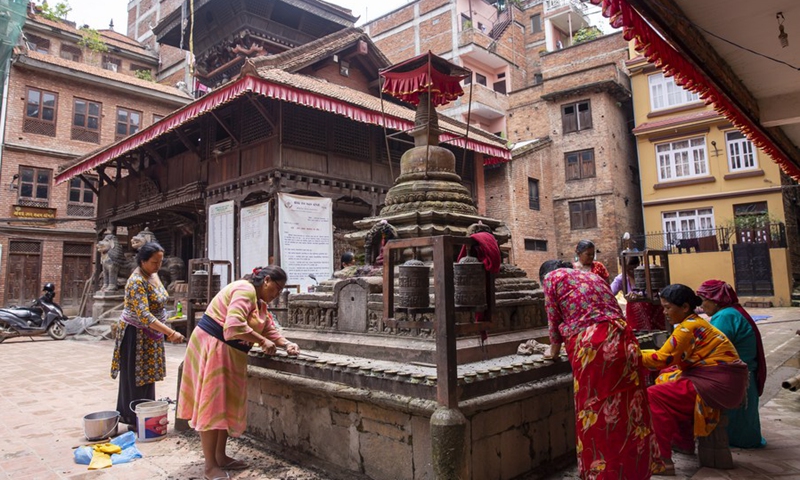 People clean the courtyard and stupa on the occasion of Sithi Nakha Festival in Lalitpur, Nepal, June 5, 2022.(Photo: Xinhua)