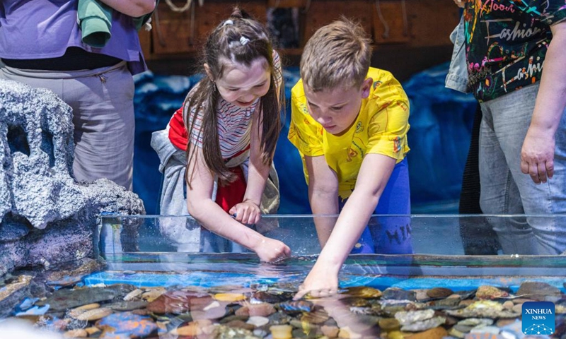 Children are encouraged to touch clams at the Primorsky Aquarium on the World Oceans Day in Vladivostok, Russia, June 8, 2022. June 8 marks World Oceans Day.(Photo: Xinhua)
